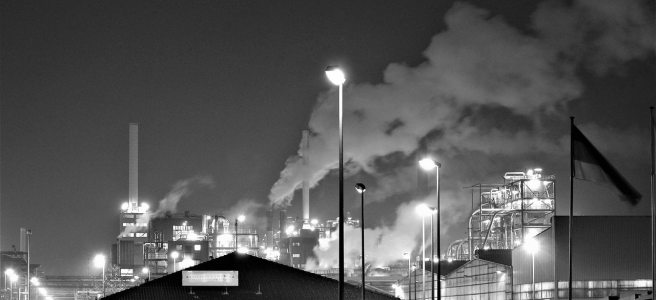 Black and white image of smoke billowing from an industry